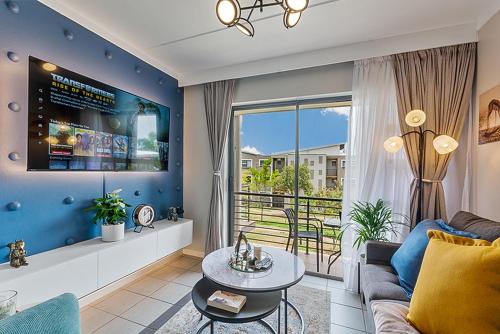 a living room with a couch and a large window at Modern 2 Bed Apartment-Self Check In-Next to Dainfern Square Shopping Centre in Sandton
