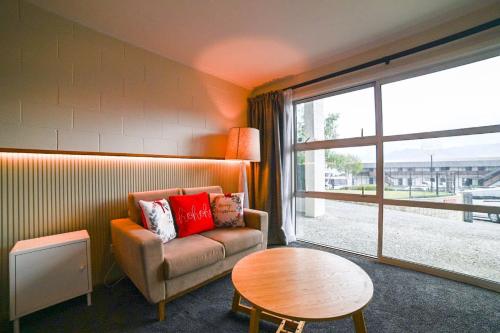 a living room with a couch and a table and a window at Starlight Lakeview Vista - 5BR Hideaway & Hot Tub in Lake Tekapo