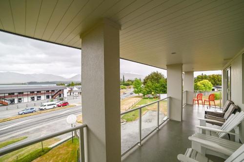 a balcony with chairs and a view of a highway at Starlight Lakeview Vista - 5BR Hideaway & Hot Tub in Lake Tekapo
