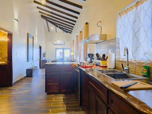 a large kitchen with wooden cabinets and a sink at Louis' Apartments in Placencia Village