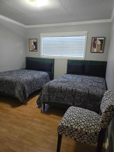 a bedroom with two beds and a chair and a window at 1976HoustonGem Luminous PvTPool & HotTub DT20mins for LRG Families 6Beds 2Bath in Houston