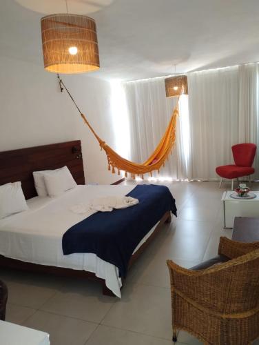 a bedroom with a bed and a hammock in it at Pousada Recanto Ha Mar in Maceió