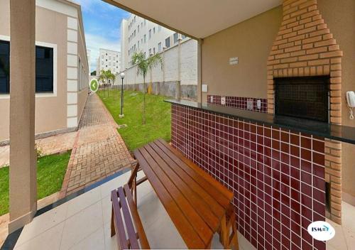 a balcony with a wooden bench and a fireplace at Apto perto do Hotel Premium com garagem, 3 camas, 2 quartos, portaria 24h in Campinas