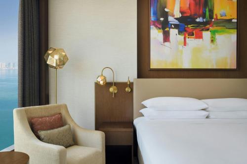 a hotel room with a bed and a chair at Delta Hotels by Marriott City Center Doha in Doha