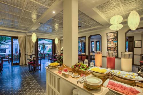 ein Restaurant mit Buffet mit Speisen darauf in der Unterkunft Cozy Hoian Villas Boutique Hotel in Hoi An