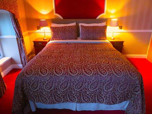 a large bed in a room with two lamps at Albany Lodge in Portrush