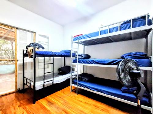 a room with three bunk beds and a fan at Sétimo Hostel 7 ll in Sao Paulo