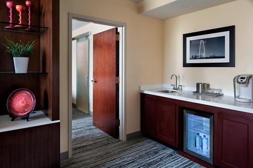 a bathroom with a sink and a counter with a mirror at Marriott DFW Airport South in Fort Worth