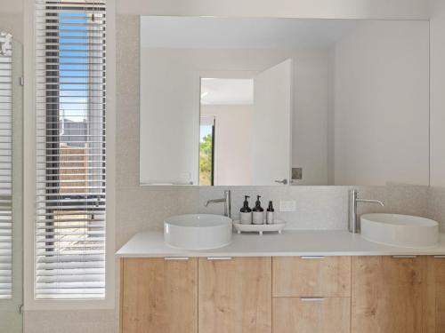 a bathroom with two sinks and a mirror at Wirilda Retreat in Inverloch