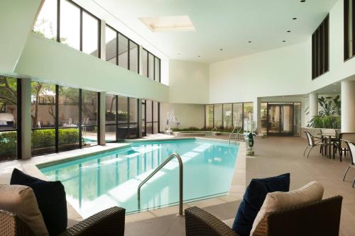 a swimming pool in a building with windows at Dallas/Fort Worth Airport Marriott in Irving