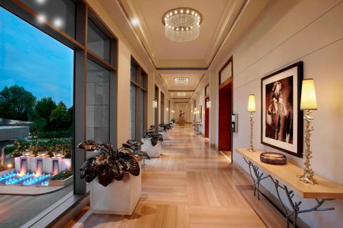 a hallway with potted plants and windows in a building at ITC Gardenia, a Luxury Collection Hotel, Bengaluru in Bengaluru