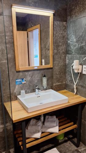 a bathroom with a white sink and a mirror at Jane's - Cozy Lakeside Studio in Liptovský Mikuláš