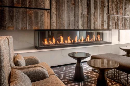 a fireplace in a room with chairs and tables at Denver Marriott Tech Center in Greenwood Village