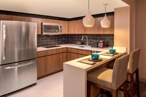a kitchen with a stainless steel refrigerator and wooden cabinets at Denver Marriott Tech Center in Greenwood Village