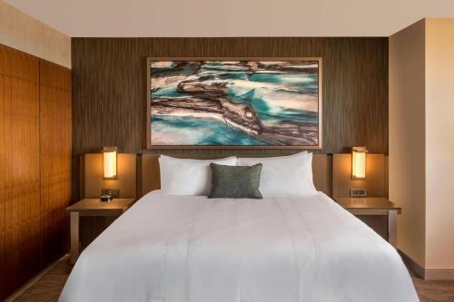 a bedroom with a large white bed with two lamps at Denver Marriott Tech Center in Greenwood Village