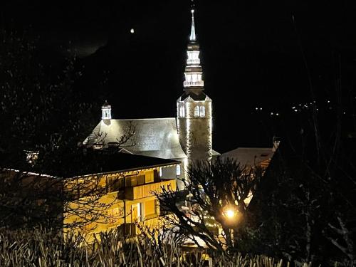 a large building with a clock tower at night at Grand studio Combloux - Vue Mont Blanc in Combloux