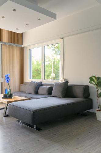 a living room with a couch and a window at Eclipse Vouliagmeni Center in Athens