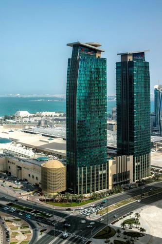 a group of tall buildings in a city with traffic at Marriott Marquis City Center Doha Hotel in Doha