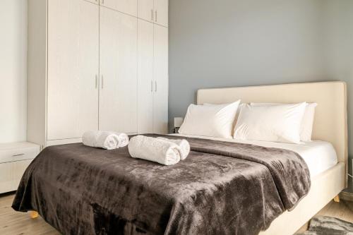 a bedroom with a bed with two towels on it at Eclipse Vouliagmeni Center in Athens