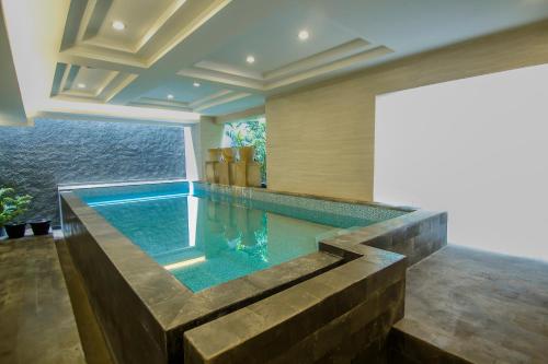ジョグジャカルタにあるDe Laxston Hotel Yogyakarta, Azana Hotels Collectionの水辺の景色を望む家のスイミングプール