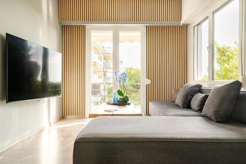 a living room with a couch and a large window at Eclipse Vouliagmeni Center in Athens