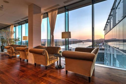 a room with chairs and tables and large windows at Grand Hotel River Park, a Luxury Collection Hotel, Bratislava in Bratislava