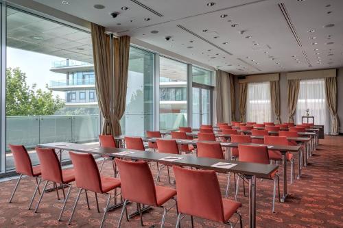 a conference room with tables and red chairs at Grand Hotel River Park, a Luxury Collection Hotel, Bratislava in Bratislava