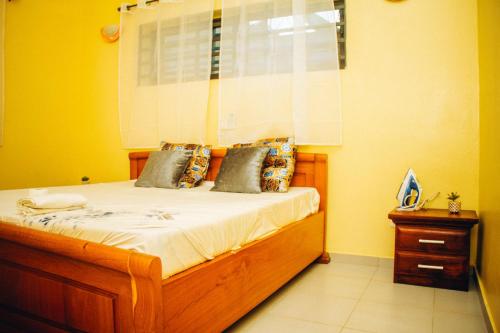 a bedroom with a bed in a yellow room at maison 3 pièces tranquille à Calavi in Ouékè-Zoumè