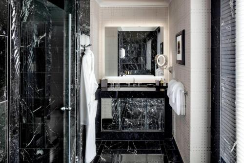 a black and white bathroom with a shower and a sink at The Liberty, a Luxury Collection Hotel, Boston in Boston