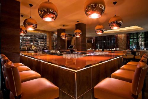 a bar in a restaurant with brown chairs and lights at The Liberty, a Luxury Collection Hotel, Boston in Boston