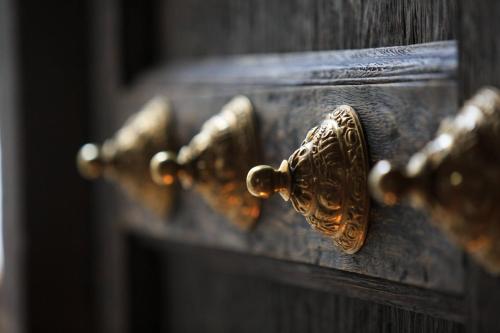 a close up of a wooden door with gold knobs at JW Marriott El Convento Cusco in Cusco