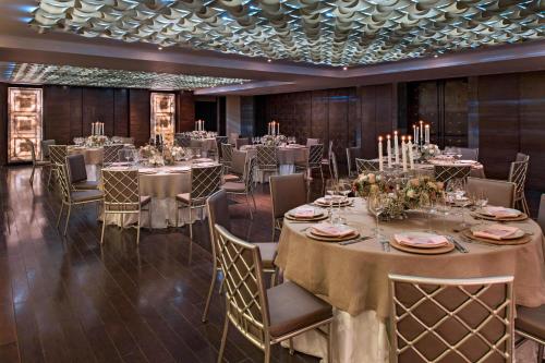 a banquet room with tables and chairs with candles at JW Marriott El Convento Cusco in Cusco