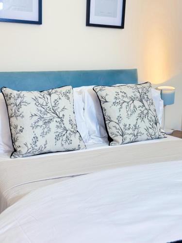 a white bed with two pillows on top of it at Glasgow City Centre Stylish Flat in Glasgow