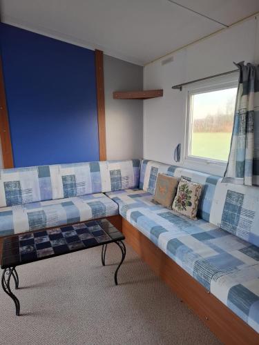 Cette chambre dispose d'un grand canapé et d'une fenêtre. dans l'établissement Maison de campagne, 17 couchages, à Tresson