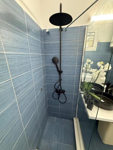 a bathroom with a shower with blue tiles at Eclipse Vouliagmeni Center in Athens
