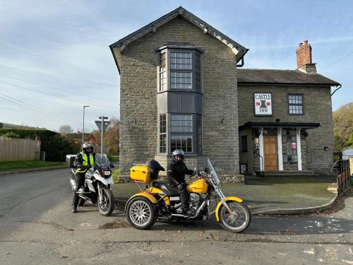 two people on motorcycles parked in front of a house at Castle Inn in Knighton