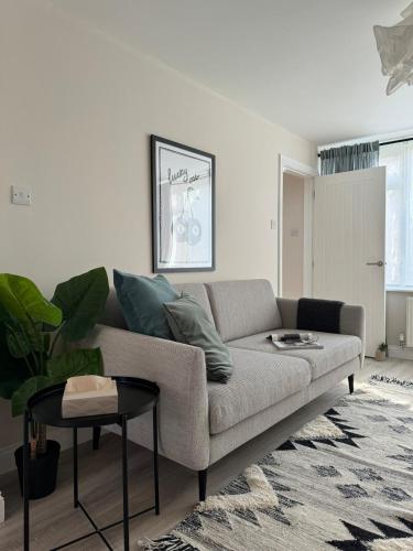 a living room with a couch and a table at Stylish & spacious home in the Chilterns in Chinnor