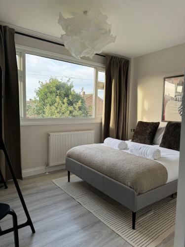 a bedroom with a bed and a large window at Stylish & spacious home in the Chilterns in Chinnor
