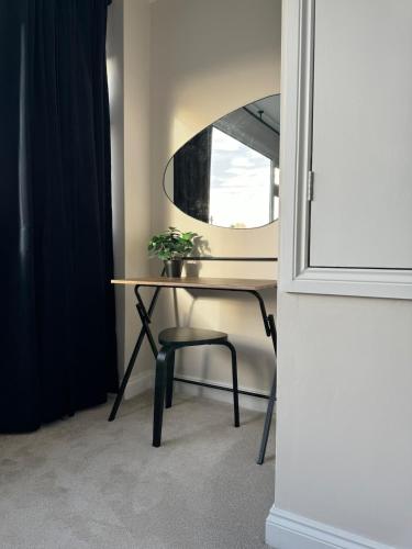 a table with a chair and a mirror at Stylish & spacious home in the Chilterns in Chinnor