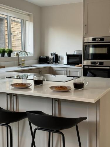 a kitchen with a island with plates of food on it at Stylish & spacious home in the Chilterns in Chinnor