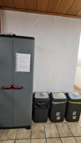two trash cans and a refrigerator with three trash cans at Gästehaus Zimmer #5 Jülich in Jülich