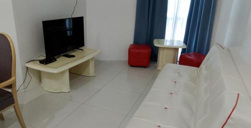 a living room with a television and a white floor at Roxas Blvd Stunning Studio Condo Near US Embassy in Manila
