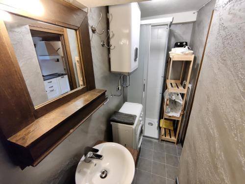 a small bathroom with a sink and a mirror at Piccolo Rifugio - Alpine Studio flat Valtournenche in Valtournenche