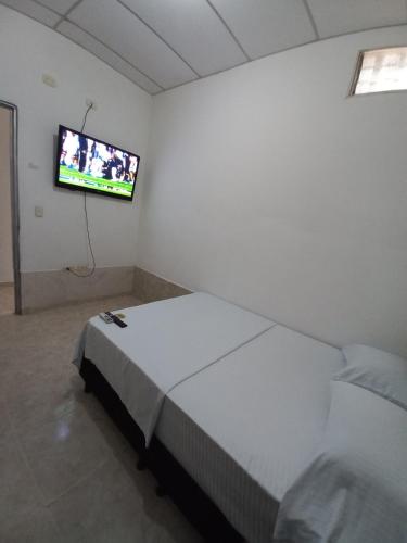 a bedroom with a bed and a flat screen tv at Apartamento Jarhel in Aguachica