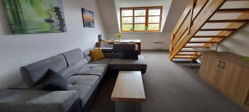 a living room with a couch and a table at Wellness apartmány Říčky v Orlických horách in Říčky