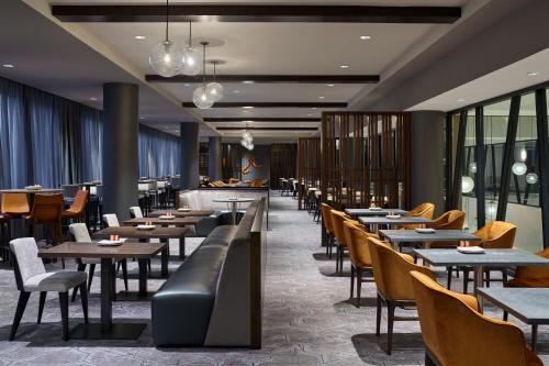 a dining room with tables and chairs and windows at Delta Hotels by Marriott Ashland Downtown in Ashland
