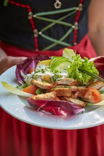a white plate of food with vegetables on it at Kurpark Flair Hotel Im Ilsetal in Ilsenburg