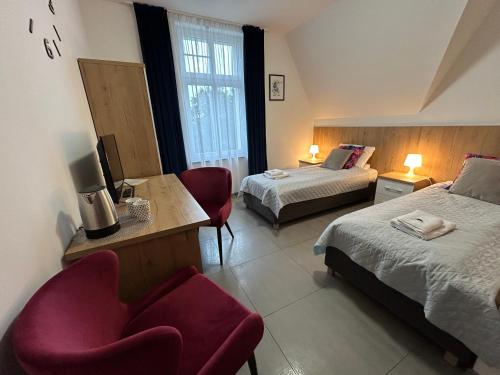 a hotel room with two beds and a chair at WILLA DobraNocka in Szklarska Poręba