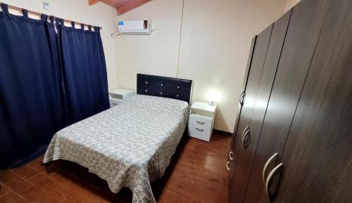 Mirando el Valle في بوتريرو دي لوس فونيس: غرفة نوم صغيرة بسرير وستائر زرقاء