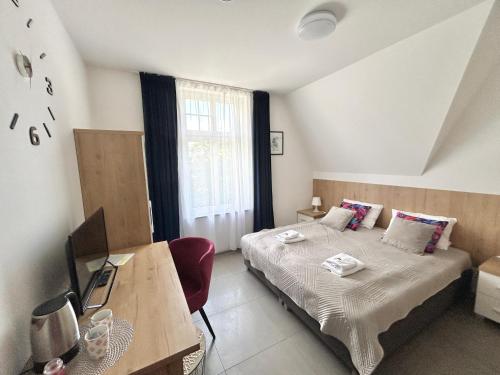 a bedroom with a bed and a table and a desk at WILLA DobraNocka in Szklarska Poręba